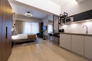 une chambre d'hôtel avec un lit et une cuisine dans l'établissement The Central Kirchberg - Smart ApartHotel, à Luxembourg