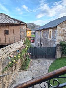 einen Blick vom Balkon eines Hauses mit einem Zaun in der Unterkunft Turismo en Babia Bajo los nidos in San Emiliano