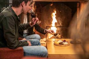 two men drinking wine in front of a fireplace at Erfgoed Bossem in Lattrop +51 photos