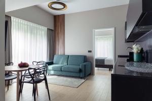 uma sala de estar com um sofá azul e uma mesa em The Central Kirchberg - Smart ApartHotel em Luxemburgo