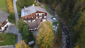 una vista aerea di una casa con auto parcheggiate di fronte di HOTEL BOSCO VERDE a Zoldo Alto