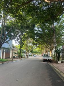 a tree lined street with a car parked on the side of the road at The Highland House in Buon Ma Thuot