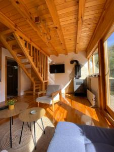 ein Wohnzimmer mit einer Treppe in einem winzigen Haus in der Unterkunft Apartman Lenka in Mokra Gora