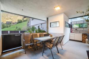 cocina y comedor con mesa y sillas en Holzer's Apartment en San Leonardo in Passiria