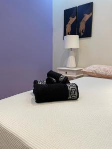 Una cama con dos toallas negras encima. en Marialva near the beach - bed&breakfast, en Corroios