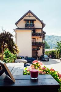 une table avec une boisson devant un bâtiment dans l'établissement Pension Casa Humor, à Gura Humorului