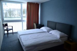 a bedroom with a bed and a large window at Maison du Lac - Séjour à la semaine in Les Brenets