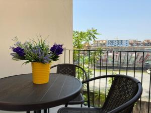 un tavolo con un vaso di fiori sul balcone di Mare Azzurro a Torre del Greco
