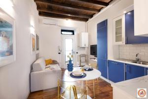 a kitchen with blue cabinets and a table in a room at Nido Milanese - Bocconi, Navigli, Duomo in Milan