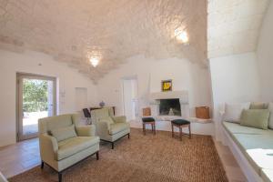 sala de estar con sofá, sillas y chimenea en Trulli & Dimore - Trulli Lorusso, en Castellana Grotte