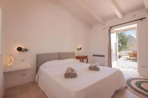 1 dormitorio con 1 cama con 2 zapatillas en Trulli & Dimore - Trulli Lorusso, en Castellana Grotte