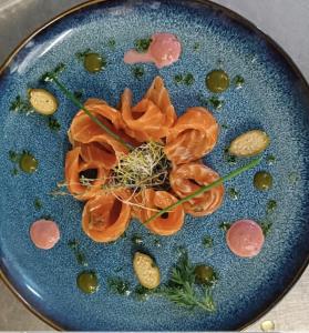 a blue plate with meat and vegetables on it at Maison du Lac - Séjour à la semaine in Les Brenets