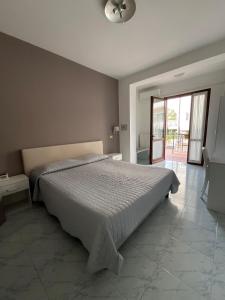 a bedroom with a bed and a sliding glass door at Hotel Saviola in Sirmione