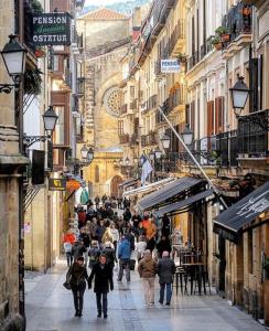 un grupo de personas caminando por una calle de la ciudad en 32 De Agosto ROOMS, en San Sebastián