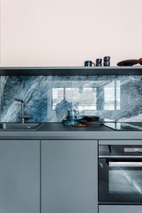 a kitchen with a sink and a counter top at Exklusive Design Appartement Deep Blue Neubau in Pfungstadt