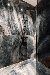 La salle de bains est pourvue d'une douche et d'un mur en pierre. dans l'établissement Exklusive Design Appartement Deep Blue Neubau, à Pfungstadt