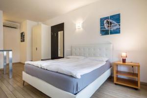 um quarto com uma grande cama branca e uma mesa em Mono Vista Lago Villa Treccani em Malcesine