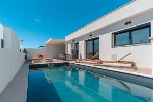 a swimming pool in the backyard of a house at Villa Tapisco in Lourinhã