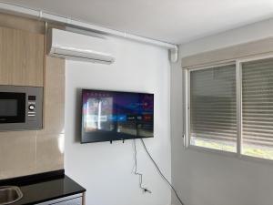 cocina con TV de pantalla plana en la pared en SAN SEBASTIAN B Apartments, en San Sebastián de los Reyes