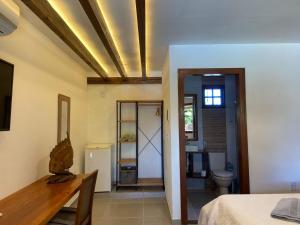 a room with a bed and a bathroom with a toilet at Aldeia Patacho in Pôrto de Pedras