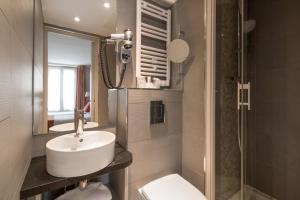 a bathroom with a sink and a toilet and a mirror at Timhotel Opera Madeleine in Paris