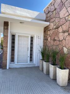 uma porta da frente de uma casa com uma parede de pedra em CASA ALQUILER TEMPORAL VILLA CABRERA em Córdoba