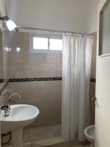 uma casa de banho com um lavatório e uma cortina de chuveiro em CASA ALQUILER TEMPORAL VILLA CABRERA em Córdoba