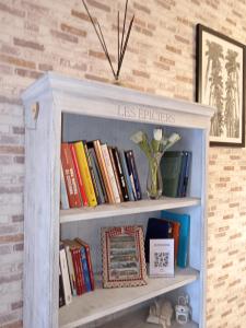een boekenplank met boeken en een vaas erop bij VILLA ESMERALDA in Pozzilli