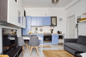 een keuken en een woonkamer met een tafel en stoelen bij Casa Azzurra - Città Studi in Milaan