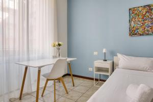 een slaapkamer met een bed, een bureau en een tafel bij Casa Azzurra - Città Studi in Milaan