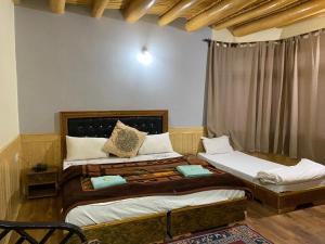 a bedroom with two beds and a window at Zaltak Guest House and Hostel in Leh