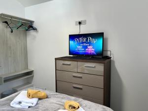 1 dormitorio con cama y vestidor con TV en The Annexe, St Andrews house hotel, Two bedrooms Sleeps 4, en Preston