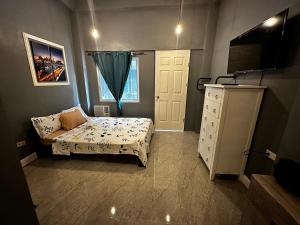 um quarto com uma cama, uma cómoda e uma janela em Limewood Residences- Bago City near Bacolod em Bago