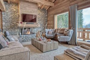 a living room with a fireplace and a stone wall at Chalet Indiana in Combloux