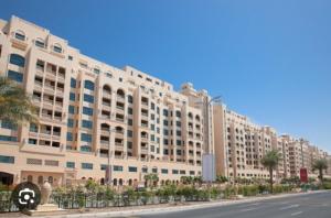 a large white building on a street next to a road at 2Bedroom Palm Jumeirah luxury Stay At Golden Mile 10 in Dubai
