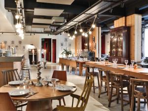 uma sala de jantar com mesas e cadeiras de madeira em MOB HOTEL Paris Les Puces em Saint-Ouen
