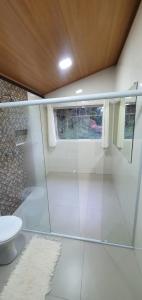 a bathroom with a glass shower with a toilet at Chalé Céu de Minas in Visconde De Maua