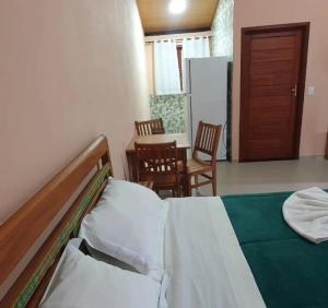 a bedroom with a bed and a table and chairs at Chalé Céu de Minas in Visconde De Maua