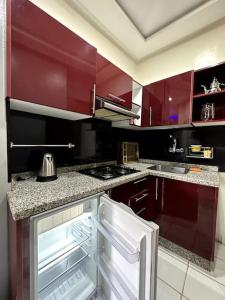 a kitchen with red cabinets and an open refrigerator at Downtown Gem: Rabat Hassan in Rabat