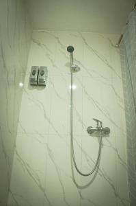 a shower in a bathroom with white marble walls at The Hills Kerinci in Kayu Aro