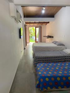 ジョアンペソアにあるPousada jardim de cabo brancoのベッド2台付きの部屋、廊下にベッド2台が備わる部屋