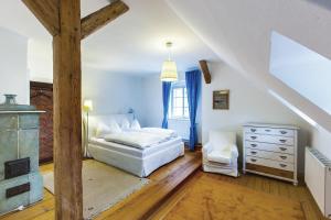 sypialnia z łóżkiem i komodą na poddaszu w obiekcie Stadthaus Mariazell w mieście Mariazell
