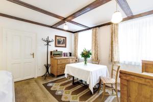 ein Zimmer mit einem Tisch mit einer Blumenvase darauf in der Unterkunft Stadthaus Mariazell in Mariazell