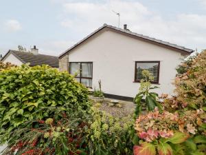 a white house with plants in front of it at Cae Teg in Llanfairpwllgwyngyll