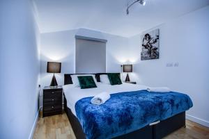 um quarto com uma cama grande e um cobertor azul em Peckham Plaza em Londres
