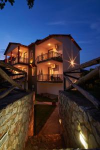 una casa di notte con un muro di pietra di Studios Kofos Limin a Porto Koufo