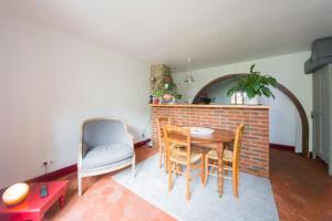 a living room with a table and chairs and a brick wall at Le charmant in Bussy-Saint-Georges