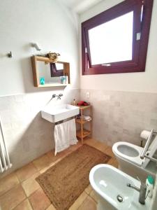 een badkamer met een wastafel, een toilet en een raam bij Villa Ghezzi Sea View in Ischia