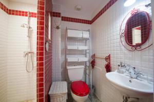 a red and white bathroom with a toilet and a sink at Le charmant in Bussy-Saint-Georges