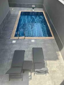 a swimming pool with three chairs in front of it at Rose 6 Comfort living at Cleopatra in Alanya